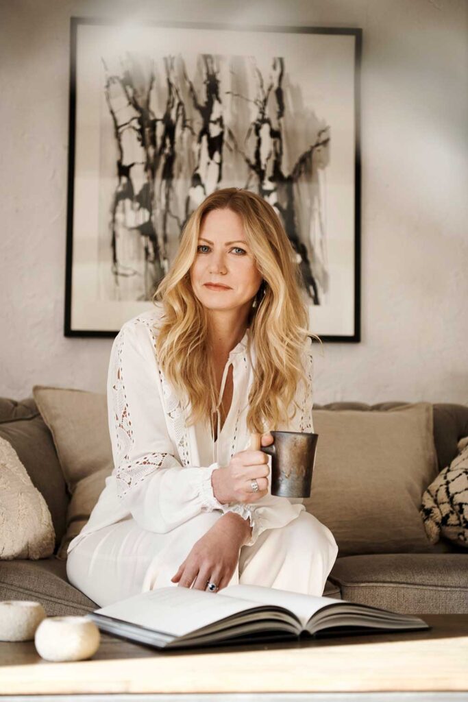 Charlotte Findlater, a luxury and high-end interior designer, sitting down holding an artisan coffee mug