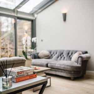 View into a lounge with a comfy grey sofa and view outside