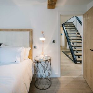 Bedroom view of half of the double bed and the door open looking out to the hallway staircase