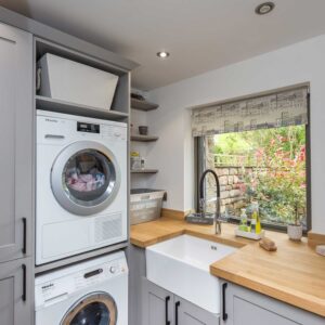 Compact and bespoke Laundry Room with appliances and belfast sink