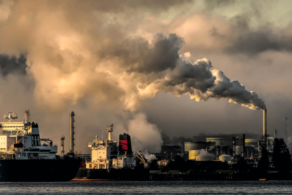 An industrial port with a huge chimney billowing out smoke