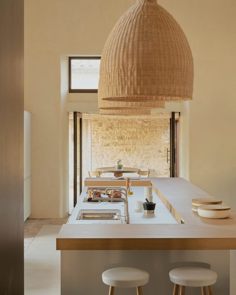 Large dome shaped rattan lights hanging over a kitchen island unit