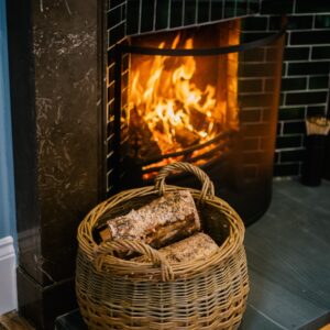 Roaring open fire and log basket close up
