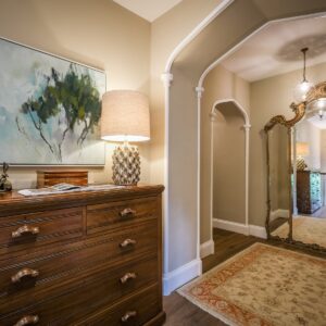 Calmly and light reflecting styled hallway with antique chest of drawers and rug