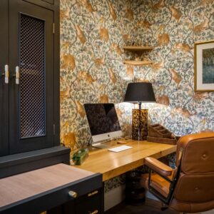 Bespoke study furniture with juxtaposition metal handles, animal wallpaper and a brown leather chair