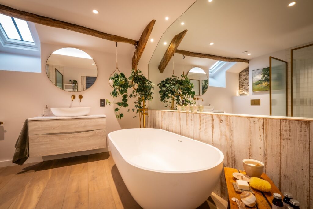 Biophilic designed ensuite bathroom with wood flooring, wall cladding in a calm Scandi style designed by Charlotte Findlater Design, an award winning interior design studio specialising in luxury, high-end residential & commercial projects that respect time, nature and people.