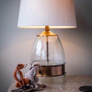 Close up of a bedside lamp with a handmade felt fox and hare on the bedside table