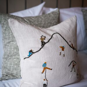 Close up of a cushion showing hikers climbing up a mountain