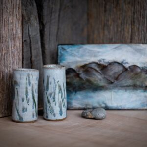 Handmade bluebell patterned ceramic pots on an oak shelf
