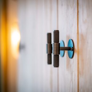 Close up black engineered wardrobe handles on oak wardrobe doors