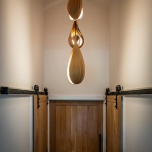 Hallway to a master bedroom with sliding oak doors and oak bent pendant lights