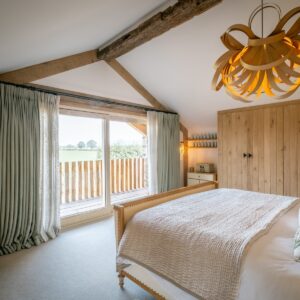 Nature and Spring design inspired master bedroom with emperor bed, oak bent pendant light and double sliding doors out to a balcony