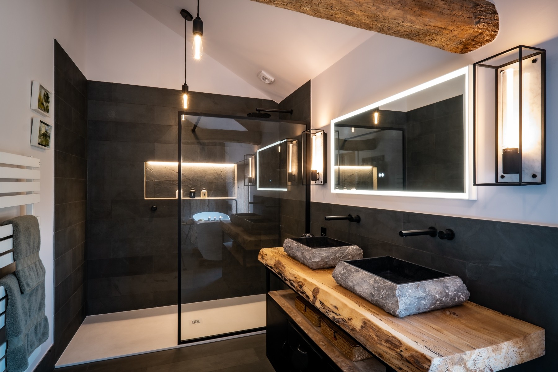 Luxury ensuite bathroom with natural stone tiling, stone basins, juxtaposed against precision engineered fixtures and fittings