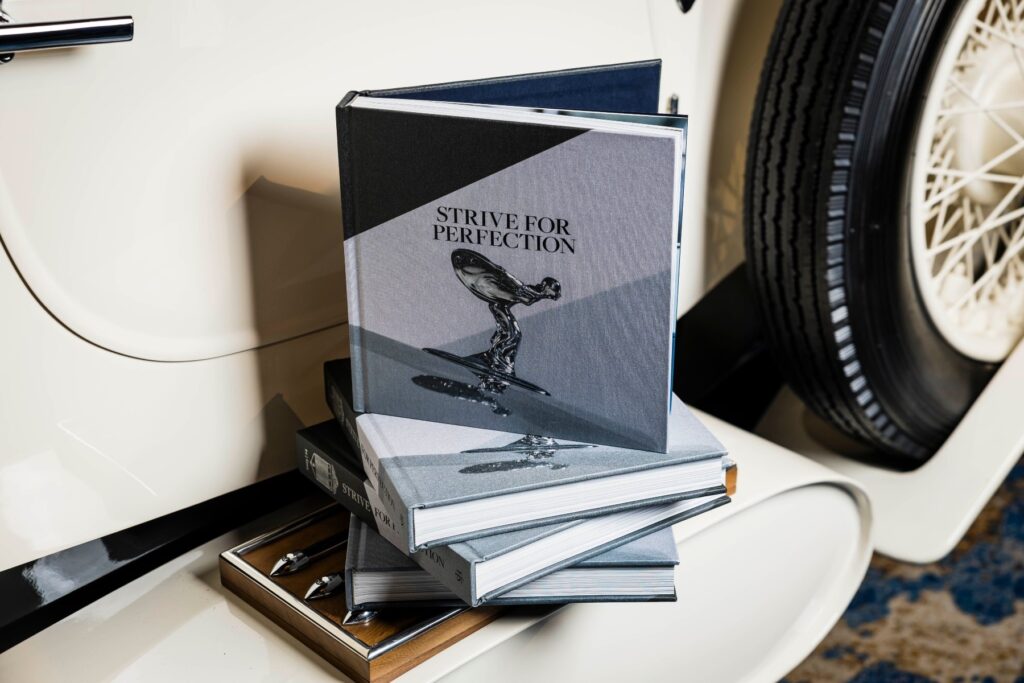 The Rolls Royce car club coffee book sitting on the side panel of a Rolls Royce car