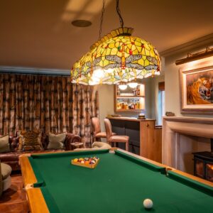 Luxury games room with bespoke Oak pool table, stone fireplace with a tiger artwork wall mounted above