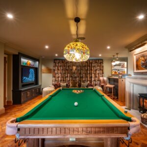 Luxury games room with bespoke Oak pool table, parquet flooring, stone fireplace, built ins and media wall