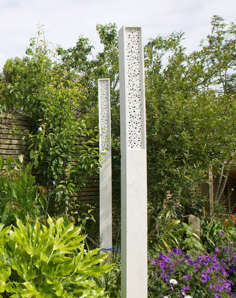A tall sculptural column with integrated bee housing