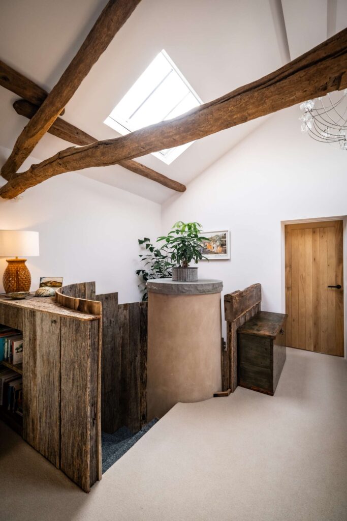 A landing and staircase flooded with natural light through a large conservation velux roof window