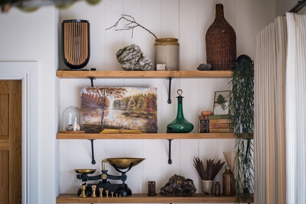 3 oak wall mounted shelves, decorated with various items, most importantly showing real plants in a biophilic design