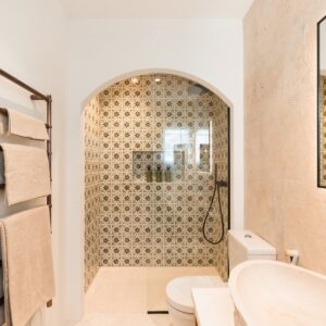 The ensuite with a focused view of the walk in shower with Menorcan hand made square tiles with an 8 pointed star in yellow and blue colours