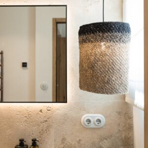 A close up of the hand weaved drop pendant in the corner of the ensuite