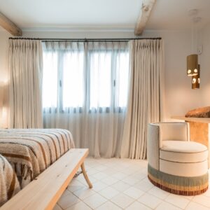 A side view focusing on a hand made stone table with feature stone pillar, mirror and swivel chair in the corner all beautifully lit up