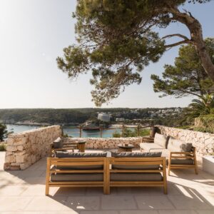 A casual seating area for 8 to 10 people surrounded by with local stone walls on a Menorcan villa terrace