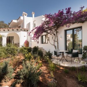 A view of a newly planted garden, with a mature pink bougainvillea on the side of the Menorcan villa