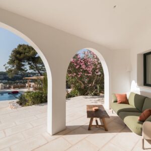 A casual seating area on the marez outdoor terrace, under the curved arch colonnade in a Menorcan villa