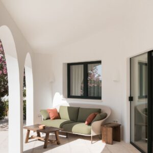 A casual seating area on the marez outdoor terrace, under the curved arch colonnade in a Menorcan villa