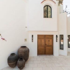 A closer view of the entrance terrace to the crisp white Menorcan villa, with large pots outside the handmade entrance doors