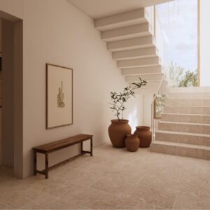 Sunlit 3D render of a Menorcan villa entrance hall with pale stone flooring, floating staircase, large glazed window, terracotta urn planters, and a simple timber bench with framed artwork.