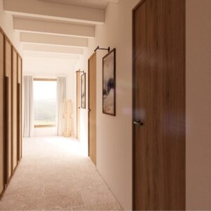 3D render set within a Menorcan villa, showing a long, bright corridor with pale plaster walls, exposed ceiling beams, limestone-look floor tiles, full-height cane-front wardrobes with timber framing on the left, timber doors with dark hardware on the right, and minimal framed artwork lit by small picture lights, leading to a sunlit window with sheer curtains and distant landscape views.