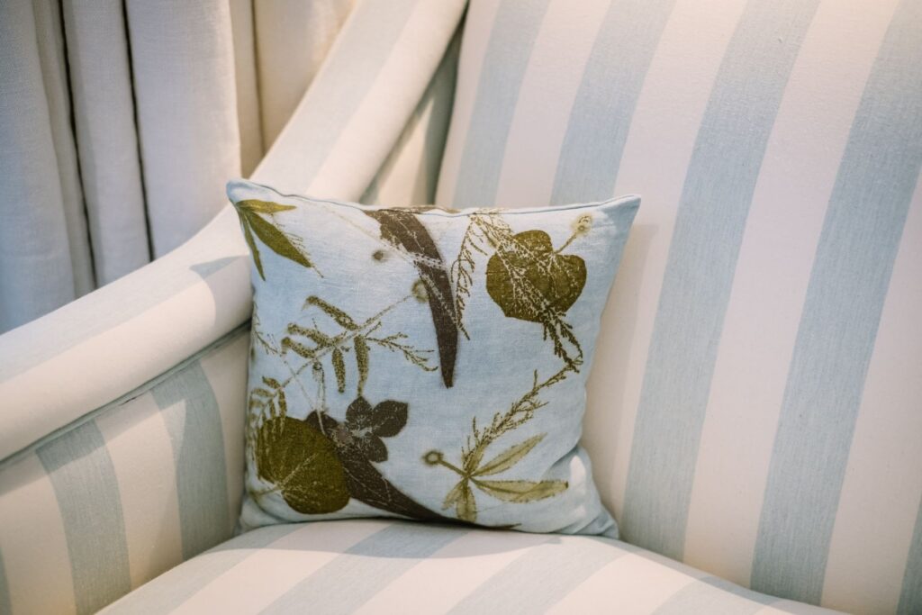Close-up of a botanical printed cushion by Turid Ljosnes Tarabay of Bona Soca, reflecting the use of naturally dyed textiles and locally inspired patterns within Menorcan interior design.
