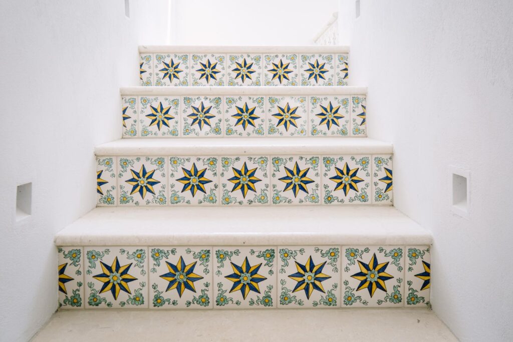 Property renovation in Menorca with hand made decorative tiled stair risers, white plaster walls and a bright Mediterranean interior.